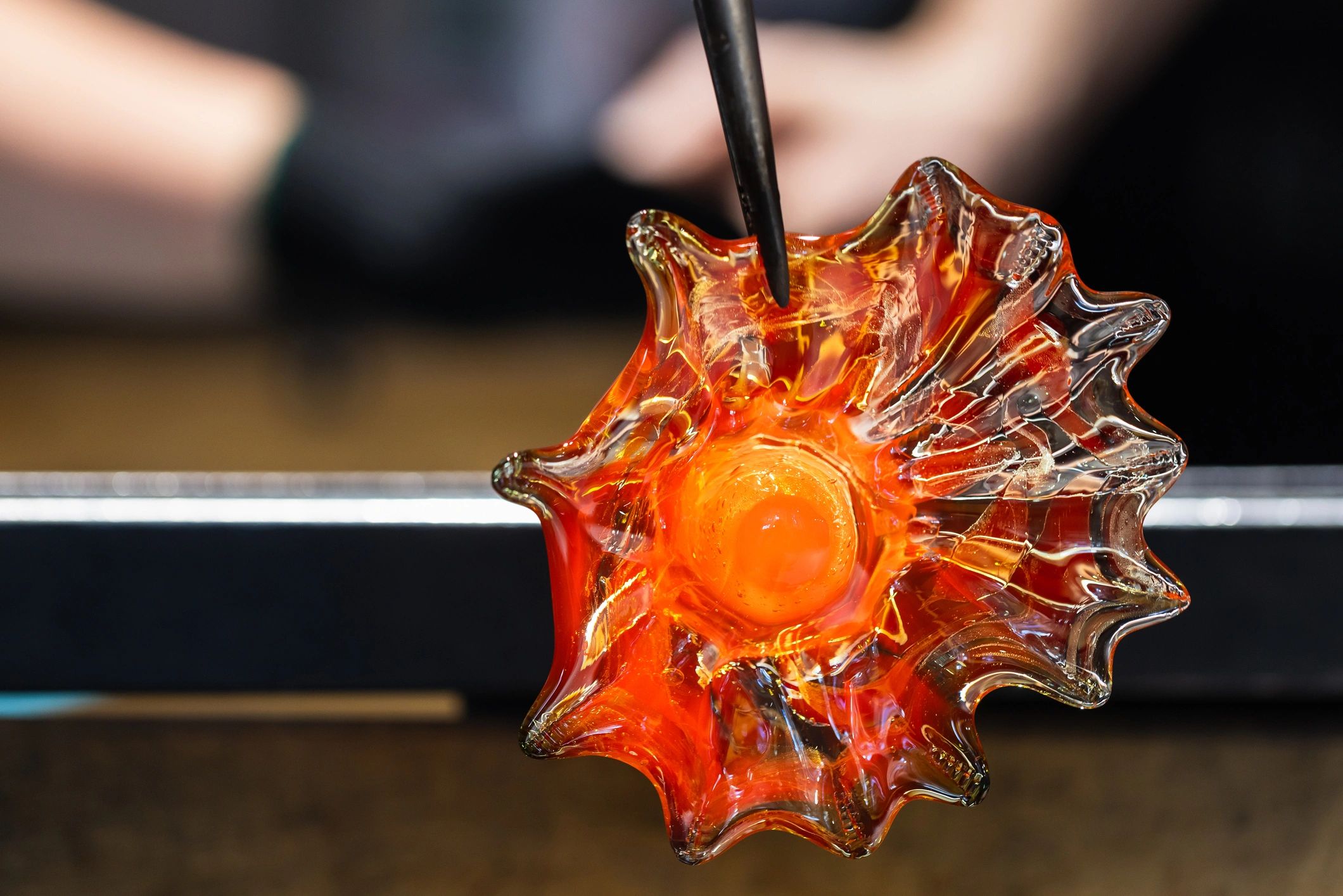 Artisan working with molten glass in a workshop